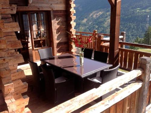 a table and chairs on the balcony of a cabin at Chalet Alouette in Grimentz