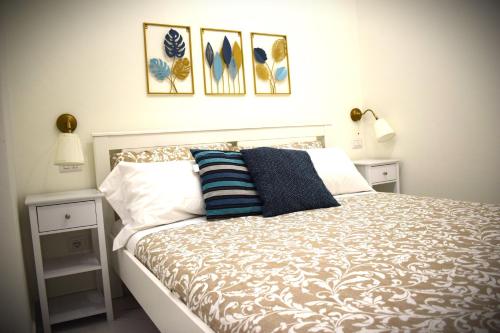 um quarto com uma cama com três fotos na parede em Il Terrazzino di Piazza Verga em Catânia