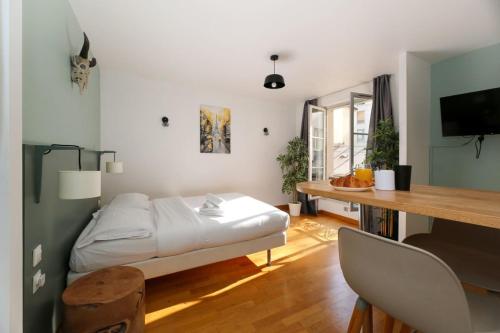 une chambre avec un lit et un bureau avec un bureau dans l'établissement 202 - Studio calme et reposant a Paris 5 - FLAT-GUEST, à Paris