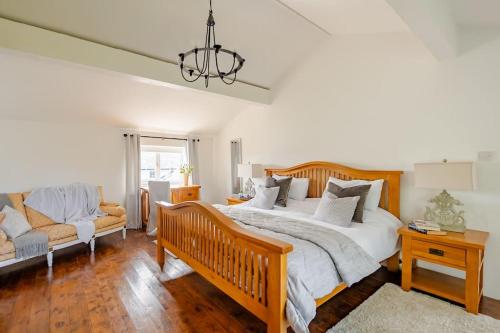 a bedroom with a large bed and a couch at Rhos y Bel Cottage Angelsey in Llangadwaladr