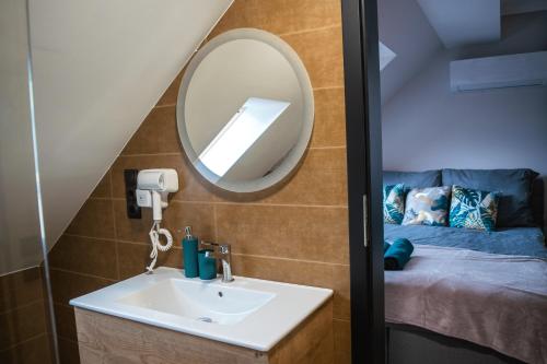 a bathroom with a sink and a mirror at Oázis Tapolca Apartman in Miskolctapolca