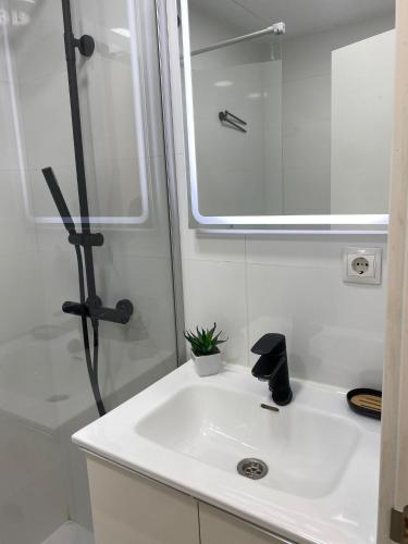 a white bathroom with a sink and a shower at Estudio con Piscina y Parking, Playa a 4 Min a Pie, Tren a 2 Min in Fuengirola