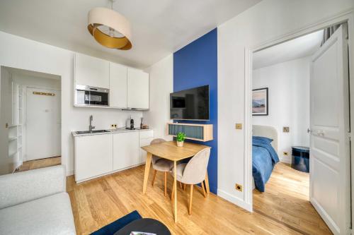 Ce petit appartement comprend une table et une chambre. dans l'établissement Le cocon des Épinettes, à Paris