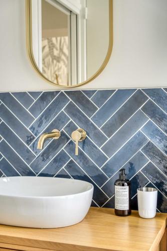une salle de bain avec un lavabo et un miroir dans l'établissement Le cocon des Épinettes, à Paris