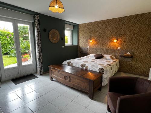 a bedroom with a bed and a wooden table at CHAMBRES D'HOTES in Loudéac