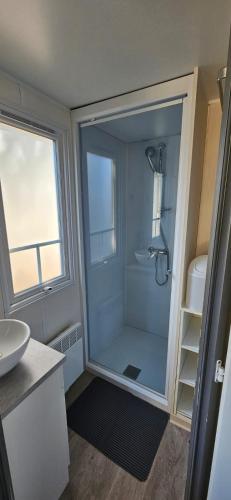 une salle de bain avec douche et lavabo dans l'établissement Mobil home 4 pers ombragé climatisé camping Marvilla parc AGDE, à Agde
