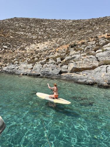 a woman sitting on a surfboard in the water at Gregory Luxury Villa by Cretevasion in Anópolis