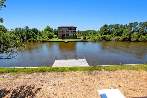 a dock in the middle of a lake with a building at Canalfront, water views, wild horses! 4x512, No Bad Days in Knotts Island
