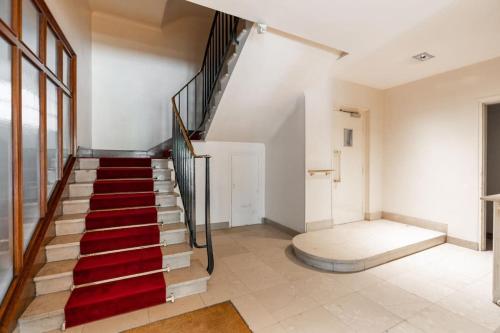 un escalier avec moquette rouge dans une maison dans l'établissement Un 3CH, 2Sdb Exquis à Trocadéro Tour Eiffel, à Paris