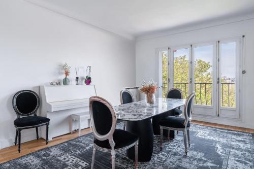 une salle à manger avec une table et des chaises dans l'établissement Un 3CH, 2Sdb Exquis à Trocadéro Tour Eiffel, à Paris