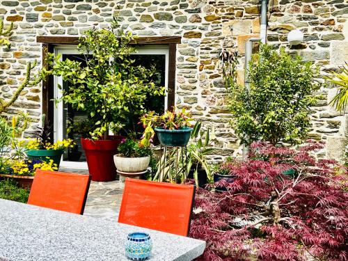 a table and chairs in a garden with plants at CHAMBRES D'HOTES in Loudéac