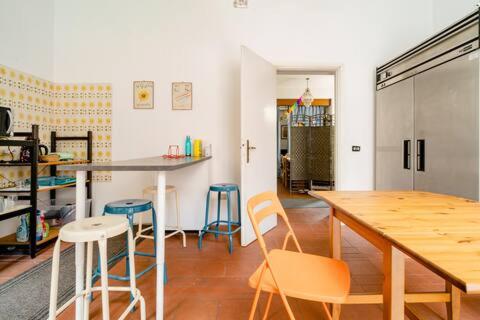 a kitchen with a table and stools in a room at Brixia Time Case - In villa con giardino in Brescia