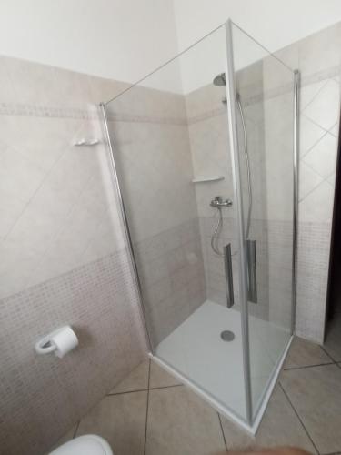 a shower with a glass door in a bathroom at villa Beatrice in Serranova
