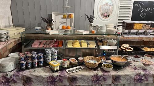 a buffet with food and drinks on a table at Riverside Apartmanház Gyula in Gyula