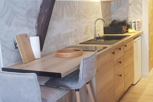 une cuisine avec un évier et un plan de travail en bois dans l'établissement Au Cœur De Limoges, à Limoges