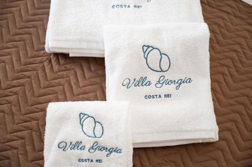 a group of white towels sitting on top of a bed at Villa Giorgia, graziosa villa a due passi dal mare in Costa Rei