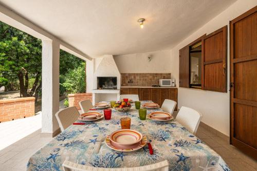 a dining room with a table with plates of food on it at Villa Giorgia, graziosa villa a due passi dal mare in Costa Rei