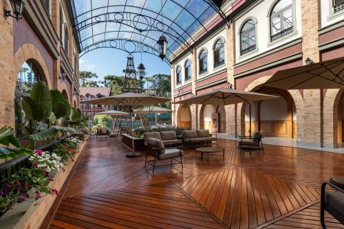 a lobby with chairs and tables and a glass ceiling at Pousada Luis XV in Campos do Jordão