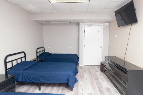 a room with two beds and a flat screen tv at 2 Bed, 1 Bath, Lower Level Loft in New Baltimore