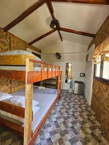 a room with two bunk beds in a house at Big BamBoo Beach Resort Sipalay in Sipalay