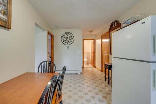 a dining room with a table and a refrigerator at WFH-Friendly Waltham Condo 1 Mi to Riverwalk Park in Waltham