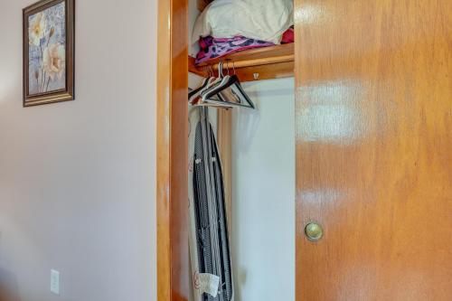 a closet with a wooden door and a coat rack at WFH-Friendly Waltham Condo 1 Mi to Riverwalk Park in Waltham