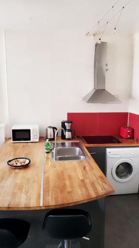 - une cuisine avec un comptoir en bois et un évier dans l'établissement La Couronne - 2 chambres près du marché, à La Rochelle