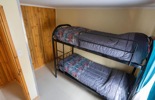 two bunk beds in a room with a door at Cabañas Rivadavia Spa in Vicuña