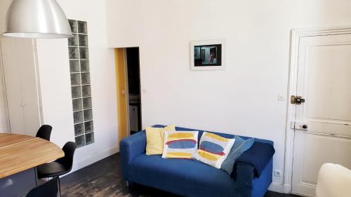 un canapé bleu dans un salon avec une table dans l'établissement La Couronne - 2 chambres près du marché, à La Rochelle