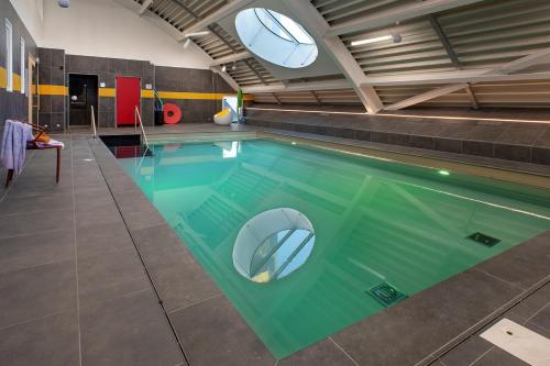 une grande piscine dans un immeuble dans l'établissement Domitys l'Esquisse, à Valenciennes