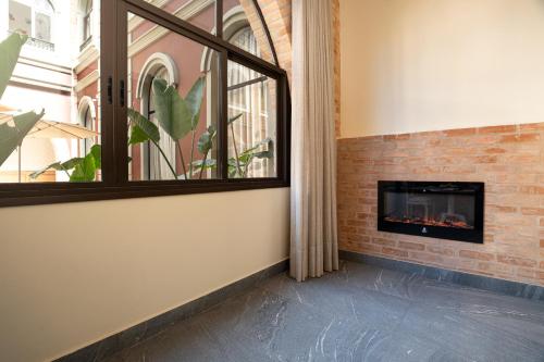 a living room with a fireplace and a window at Pousada Luis XV in Campos do Jordão