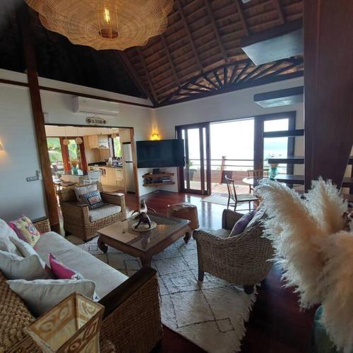 a living room with couches and chairs and a television at 180 Degree Stunning Ocean Views in Entirely Equipped Villa! in Papetoai