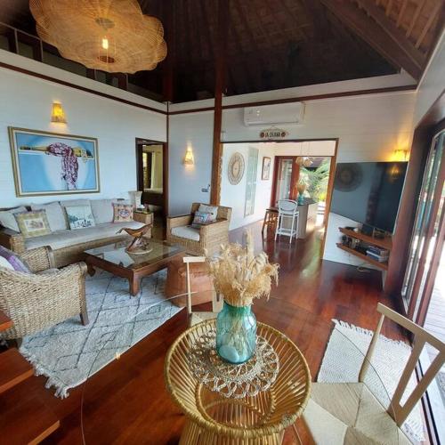 a living room with a vase of flowers on a table at 180 Degree Stunning Ocean Views in Entirely Equipped Villa! in Papetoai