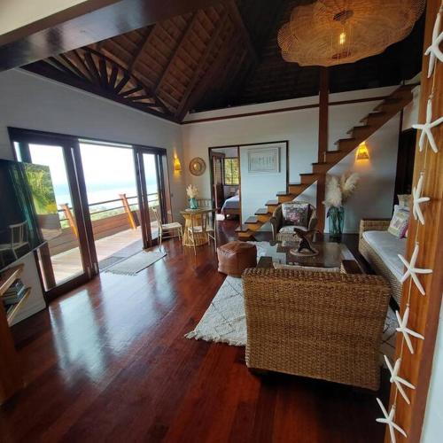 a living room with a couch and a staircase at 180 Degree Stunning Ocean Views in Entirely Equipped Villa! in Papetoai