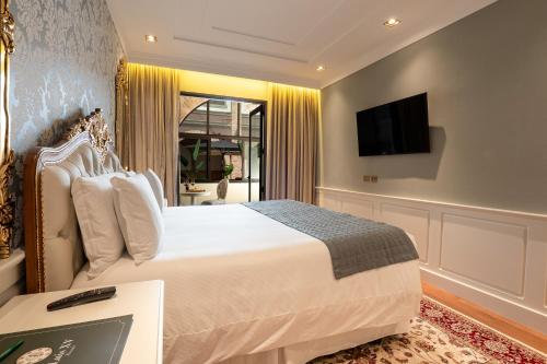 a bedroom with a bed and a tv on a wall at Pousada Luis XV in Campos do Jordão