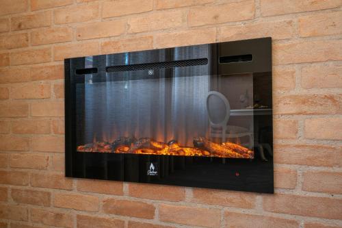 a fireplace mounted on a brick wall at Pousada Luis XV in Campos do Jordão