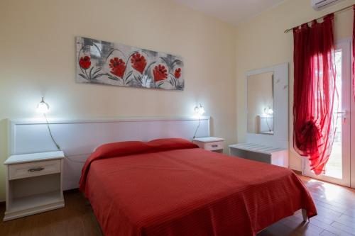 a bedroom with a red bed and two night stands at Aura Solis B&B in Leuca