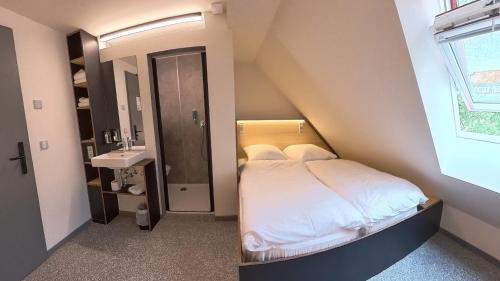 a small bedroom with a bed and a sink at Das Kittchen in Wismar