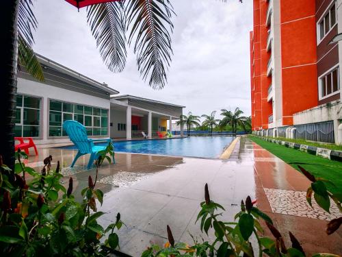 a swimming pool with a blue chair next to a building at Pavilionvillie M1T570 by irainbow in Ipoh