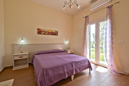 a bedroom with a purple bed and a window at Aura Solis B&B in Leuca