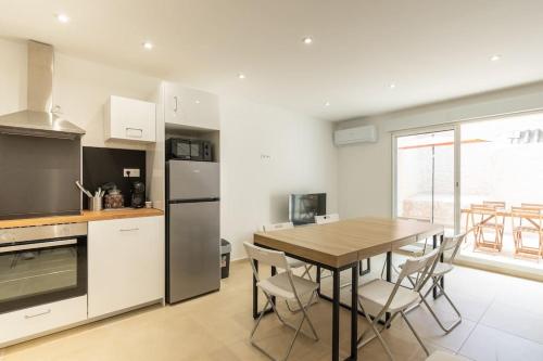 une cuisine avec une table en bois et une table et des chaises dans l'établissement Maison familiale neuve, à Marseille