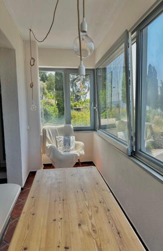 a living room with a chair and windows at Iris Sunset View Home in Samos