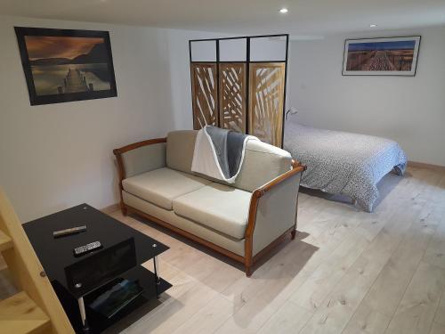 un salon avec un canapé et un lit dans l'établissement Le Blanzey, à Fougerolles