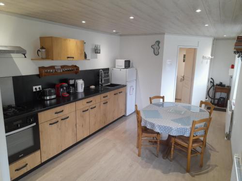 - une cuisine avec une table, une table et des chaises dans l'établissement Le Blanzey, à Fougerolles