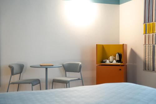 a room with a table and chairs and a bed at Sella&Mosca Casa Villamarina in Alghero