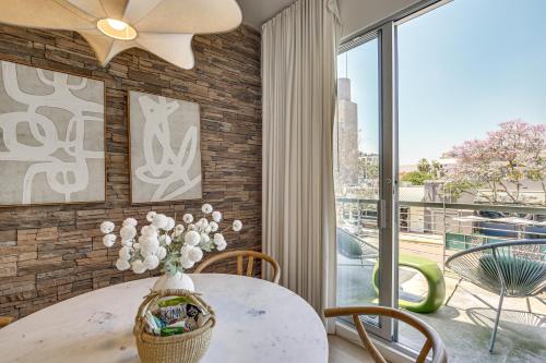 a dining room with a table with a vase of flowers at Rooftop with Views Modern Little Italy Townhome in San Diego
