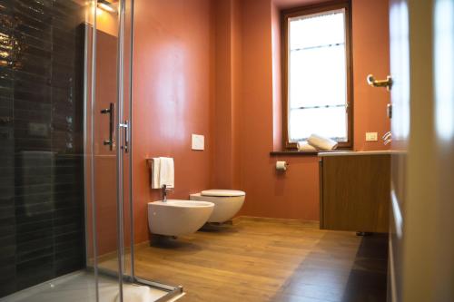 a bathroom with a toilet and a glass shower at Sella&Mosca Casa Villamarina in Alghero