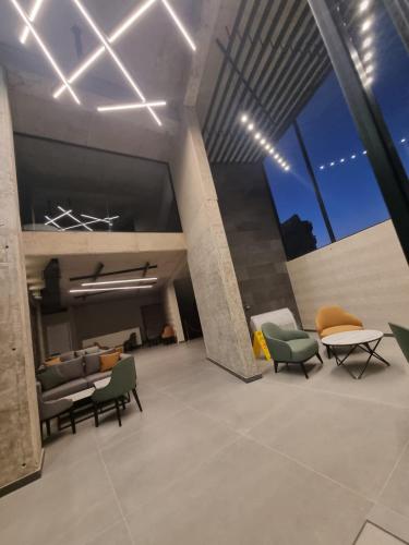 a lobby with chairs and a couch and a table at 365 UrbanLiving in Jbeil