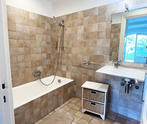 une salle de bain avec une baignoire et un lavabo dans l'établissement Studio 3 - LES SUITES DE ROBINSON - Résidence avec piscine en bord de Siagne, à Mandelieu-La-Napoule, à Mandelieu-la-Napoule