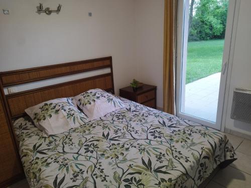 een bed in een slaapkamer naast een schuifdeur van glas bij Maisonnette drômoise in Châteauneuf-sur-Isère